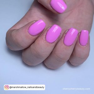 Short Square Pink Acrylic Nails On A Blue Surface