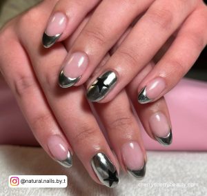 Silver Chrome French Nails With Black Stars On Ring Finger