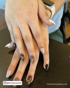 Simple Brown Acrylic Nails Almond Shape With Swirly Design Over Black Surface