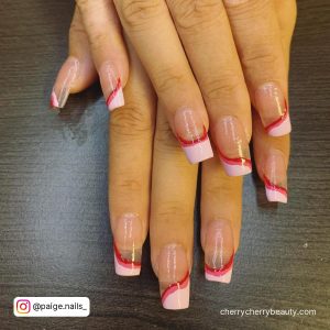 Simple Design Acrylic Nails With French Tips Over Wooden Surface