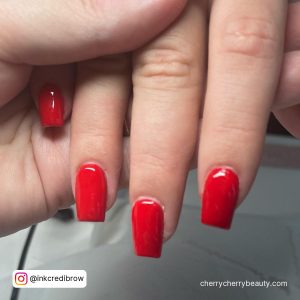 Simple Red Acrylic Nails Held By Another Hand