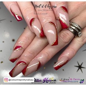 Swirly Acrylic Red And Gold Nails Over A White Surface