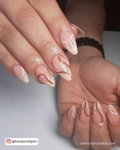 Swirly French Tip Almond Acrylic Nails Over White Surface