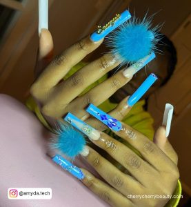Trendy Pompom Blue Acrylic Nails With Rhinestones On Light Pink Surface