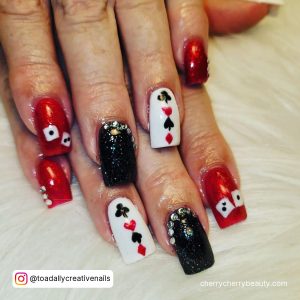 Vegas-Themed Black And Red Acrylic Nails With Glitter Over White Fur