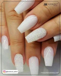 White Glitter Coffin Acrylic Nails Over White Surface