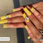 Yellow Acrylic Nail Ideas With A Butterfly On Middle Finger