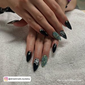 Black And Green Stiletto Nails With Web Design On One Finger