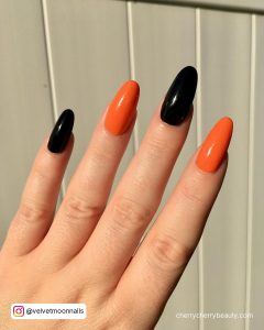 Cute Orange And Black Nails In Almond Shape