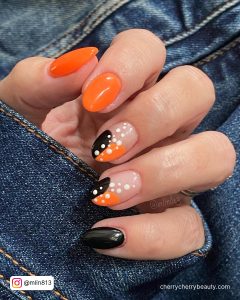 Neon Orange And Black Nails With White Spots