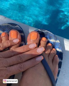 French Tip Nails With One Orange Glitter Fade