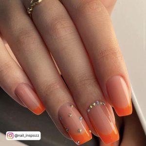 French Tip Nails With Orange Glitter